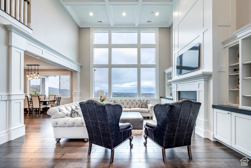 Living room featuring a high ceiling, dark wood finished floors, a fireplace, recessed lighting, and beamed ceiling