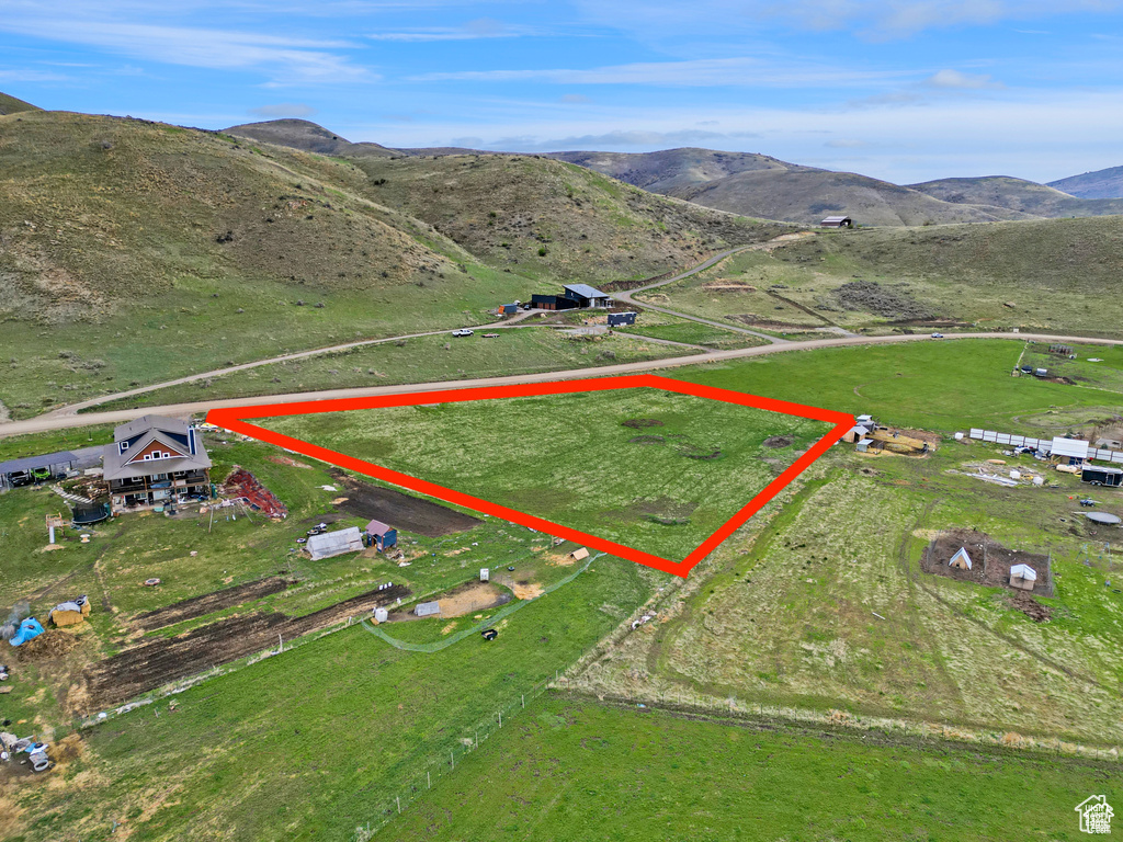 View of property location featuring property parcel outlined, mountains, and rural landscape