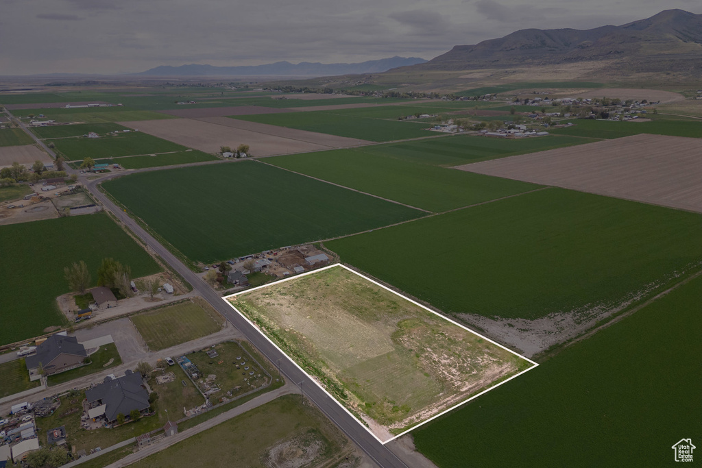 Aerial overview of property's location featuring a mountainous background, property parcel outlined, and rural landscape