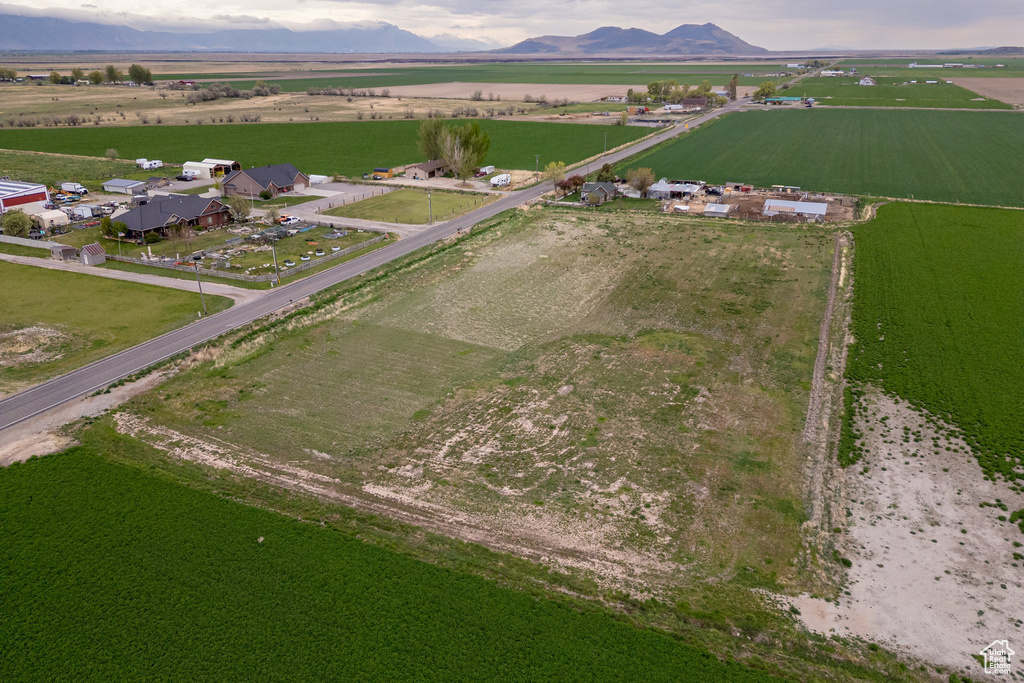 Aerial overview of property's location with rural landscape, large plots for crops, and mountains