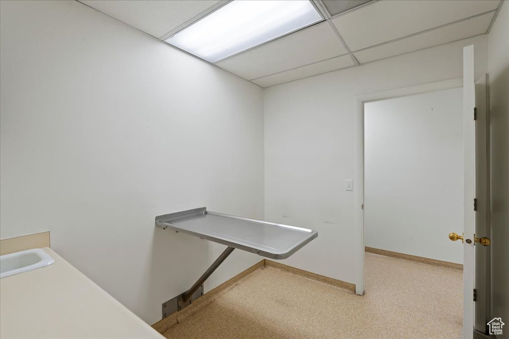 Hall with a paneled ceiling, carpet floors, and baseboards