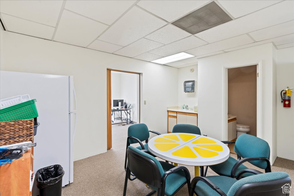 Dining space with carpet floors and a drop ceiling
