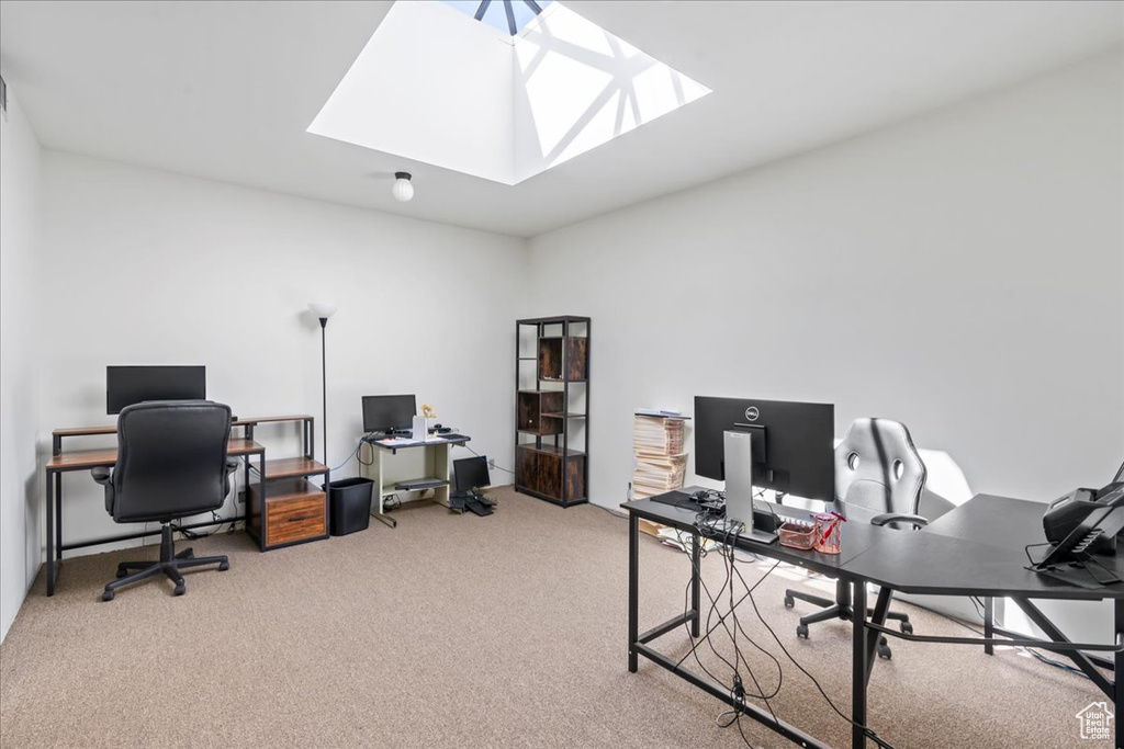 Carpeted home office with a skylight