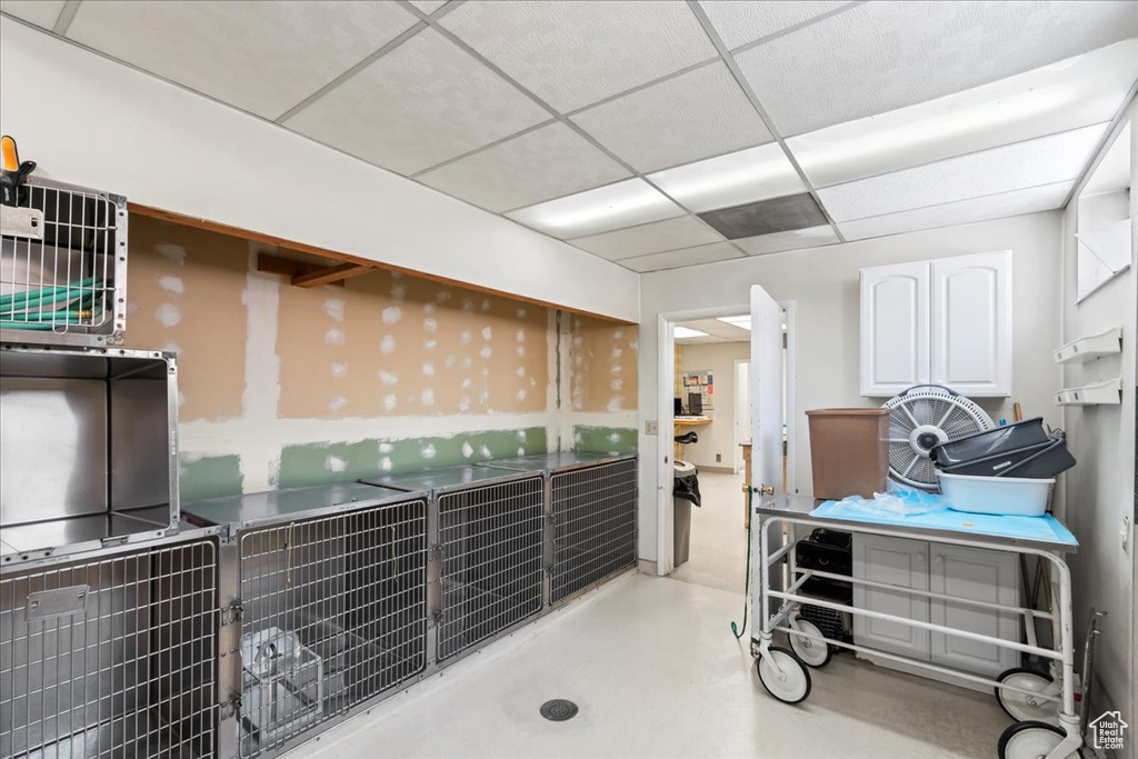 Miscellaneous room with a paneled ceiling and finished concrete floors