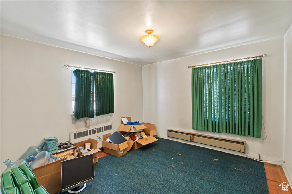 Playroom with baseboard heating and radiator heating unit