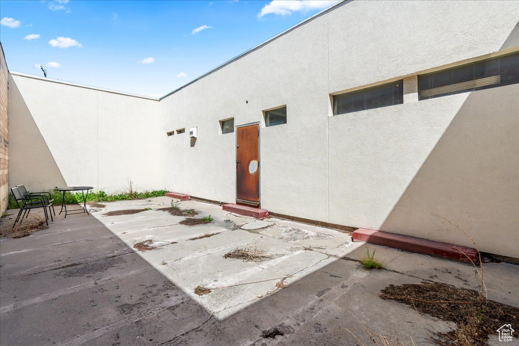 View of exterior entry with stucco siding and a patio area