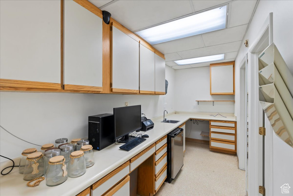 Kitchen featuring dishwasher, light countertops, an office area, and a sink
