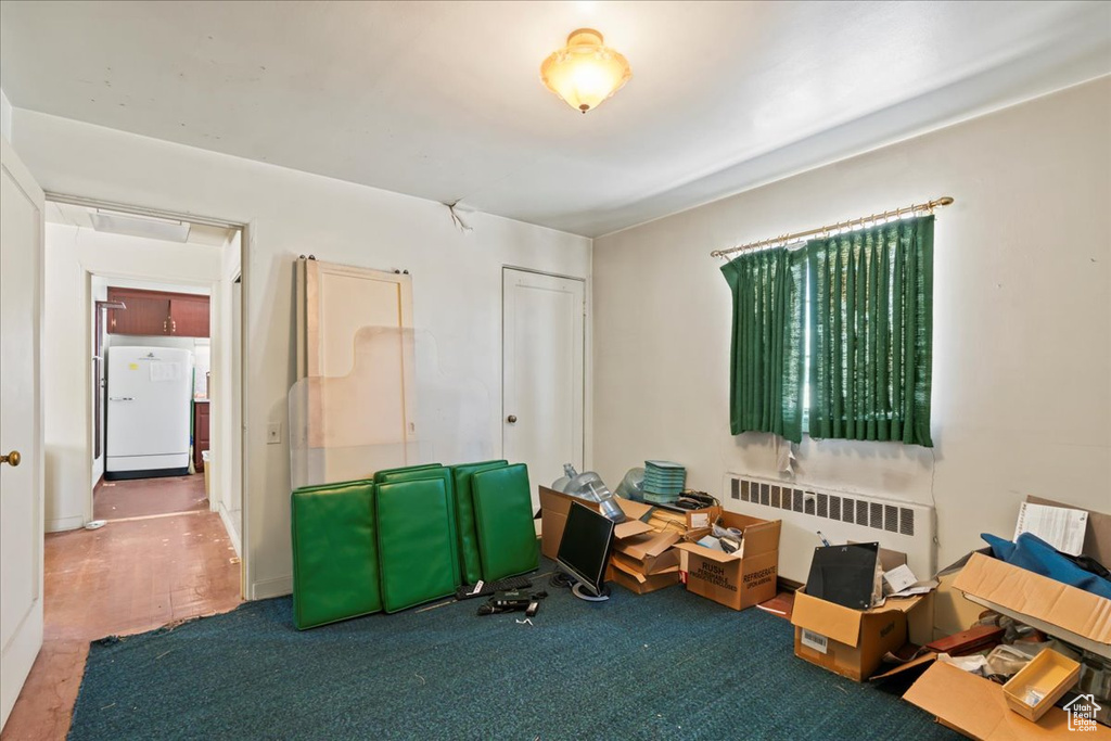 Misc room with radiator heating unit and carpet floors