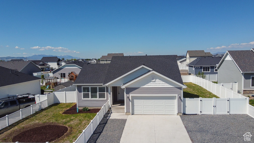 View of front of property with a residential view, an attached garage, concrete driveway, and a gate