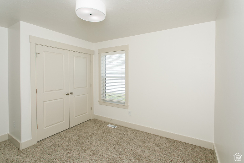 Unfurnished bedroom with carpet floors, baseboards, and a closet