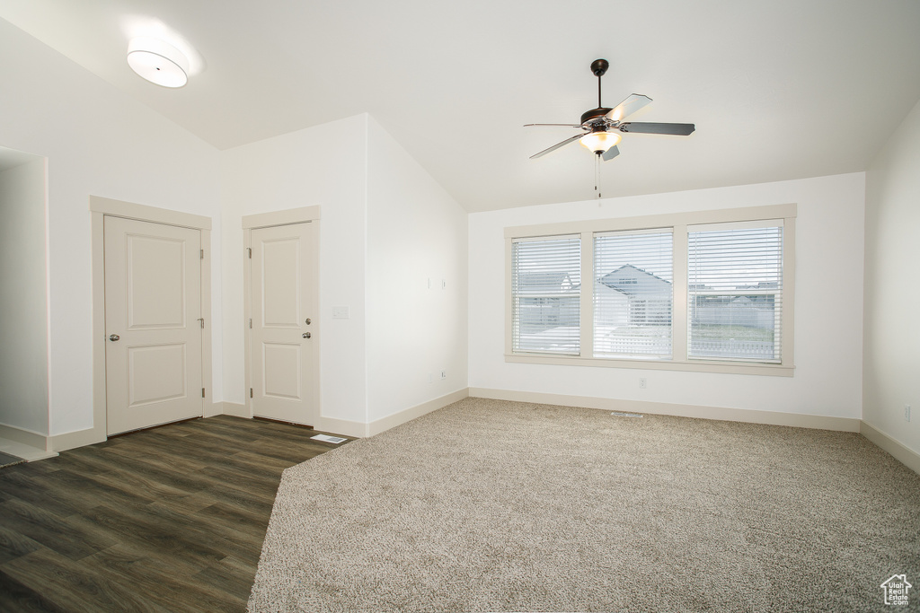 Unfurnished room with a ceiling fan, baseboards, lofted ceiling, and dark wood finished floors