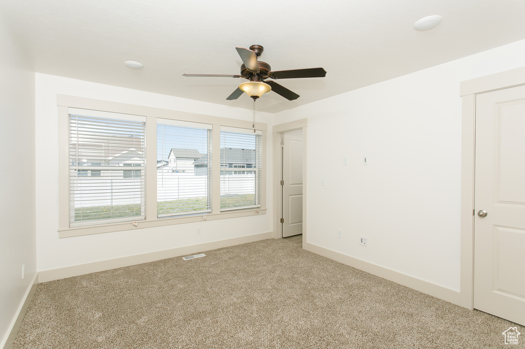 Unfurnished room with light carpet, ceiling fan, and baseboards