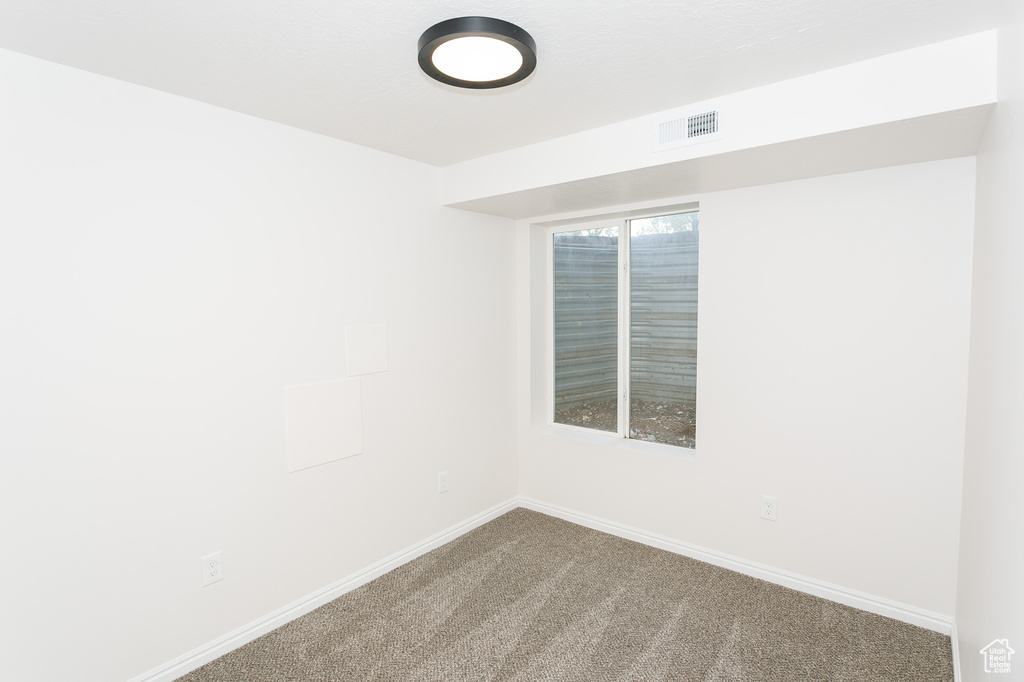 Spare room with carpet and baseboards