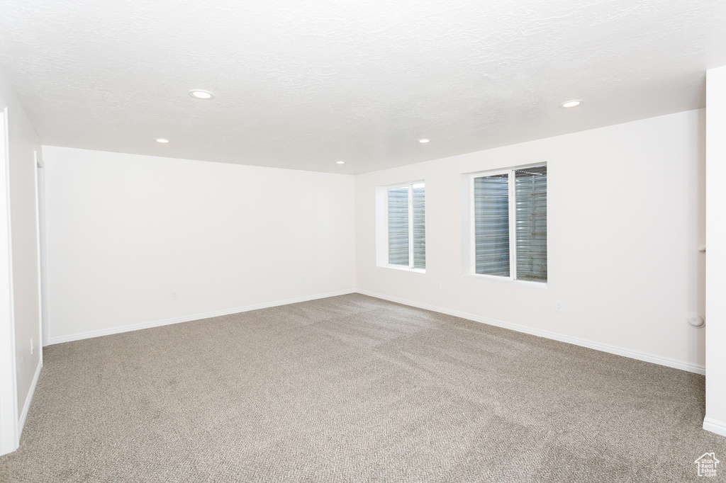 Empty room featuring carpet floors, recessed lighting, and baseboards