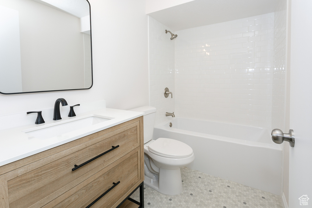 Bathroom with toilet, vanity, and  shower combination