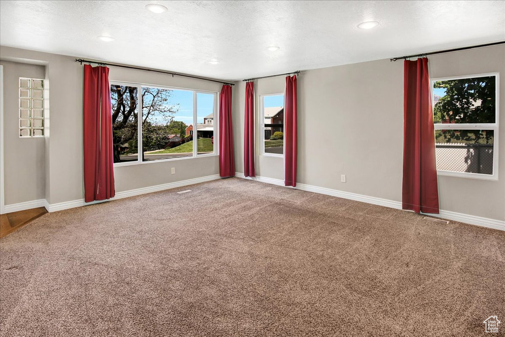 Spare room featuring carpet flooring, baseboards, recessed lighting, and a textured ceiling