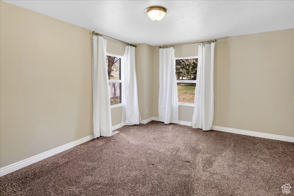 Empty room featuring carpet floors and baseboards
