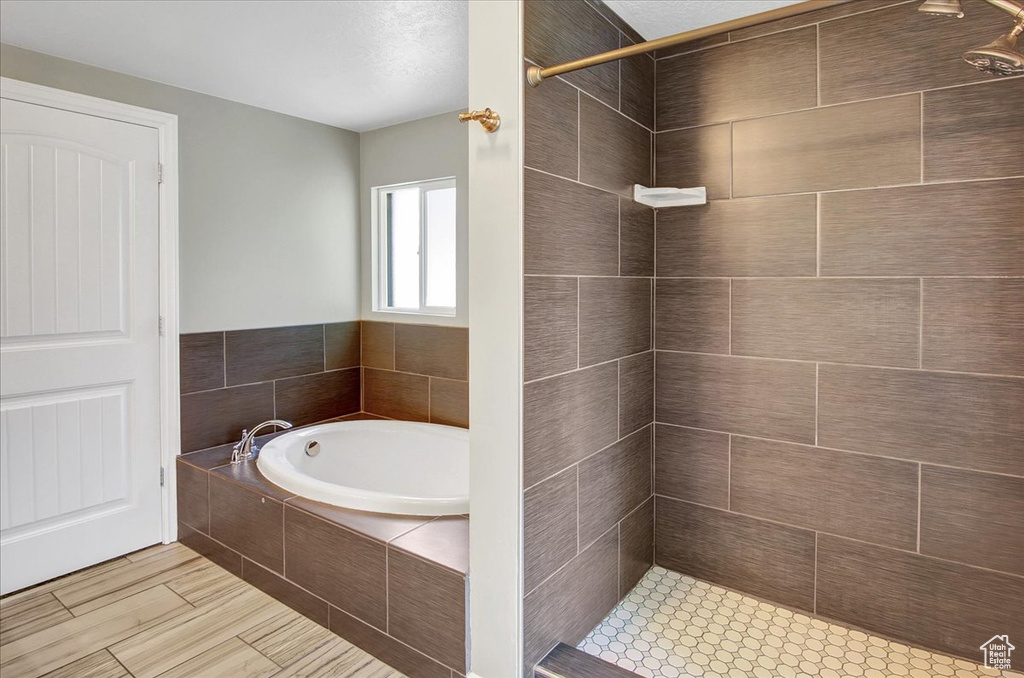 Full bathroom featuring a tile shower and a bath