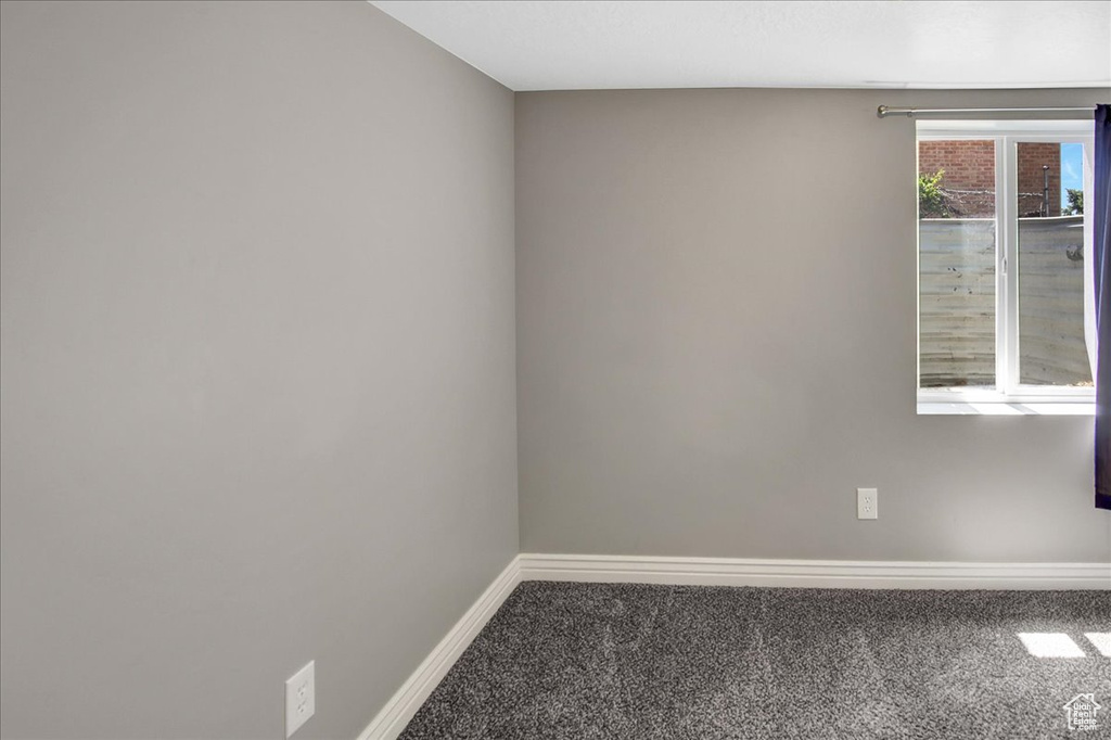 Carpeted spare room featuring baseboards