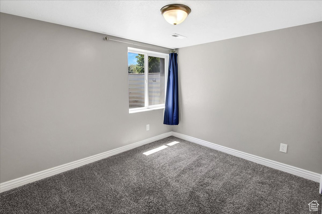 Carpeted spare room with baseboards