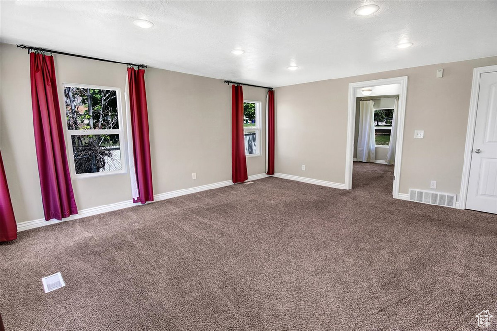 Carpeted empty room with healthy amount of natural light, baseboards, and recessed lighting