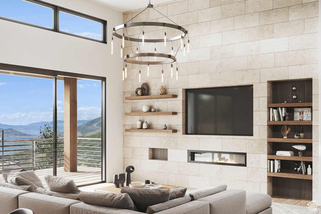 Living room featuring a mountain view, wood finished floors, a fireplace, a high ceiling, and built in shelves