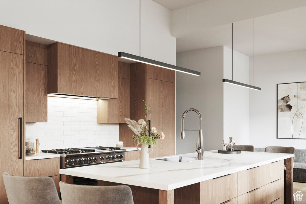 Kitchen with modern cabinets, a sink, tasteful backsplash, and a center island with sink