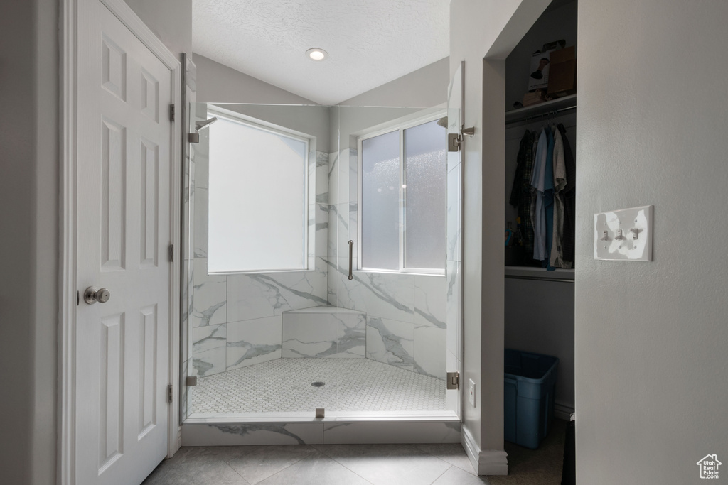 Full bathroom with a marble finish shower, tile patterned floors, baseboards, and recessed lighting