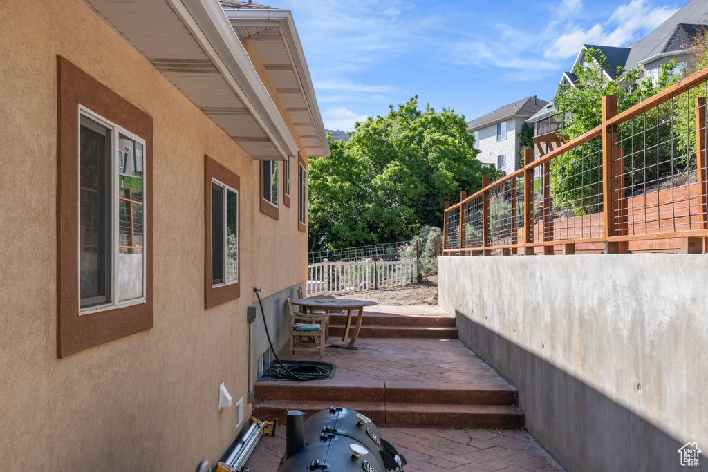 View of side of home featuring fence and stucco siding