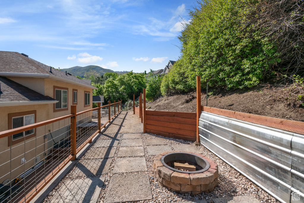 View of patio / terrace with a fire pit, fence, and a mountain view