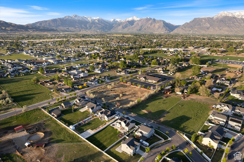 Aerial view of property and surrounding area with a mountainous background and nearby suburban area
