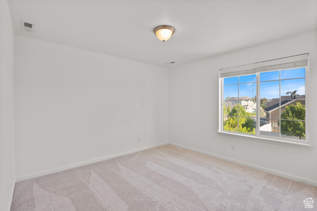 Carpeted empty room featuring baseboards