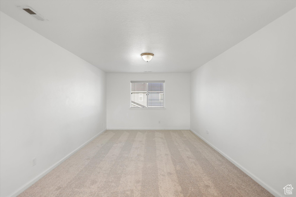 Unfurnished room featuring baseboards and light colored carpet