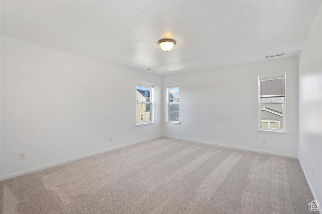 Unfurnished room with light carpet and baseboards