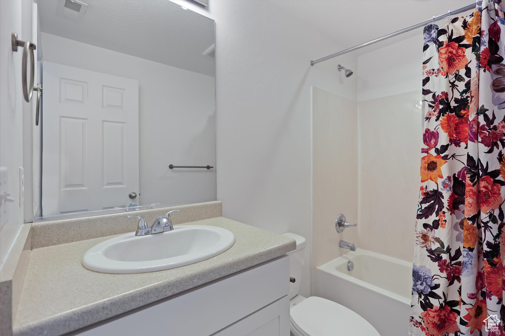 Full bathroom with vanity, toilet, and shower / tub combo