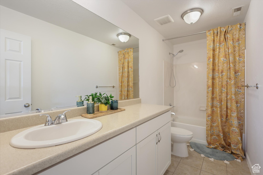 Full bath featuring tile patterned floors, shower / tub combo with curtain, vanity, and toilet