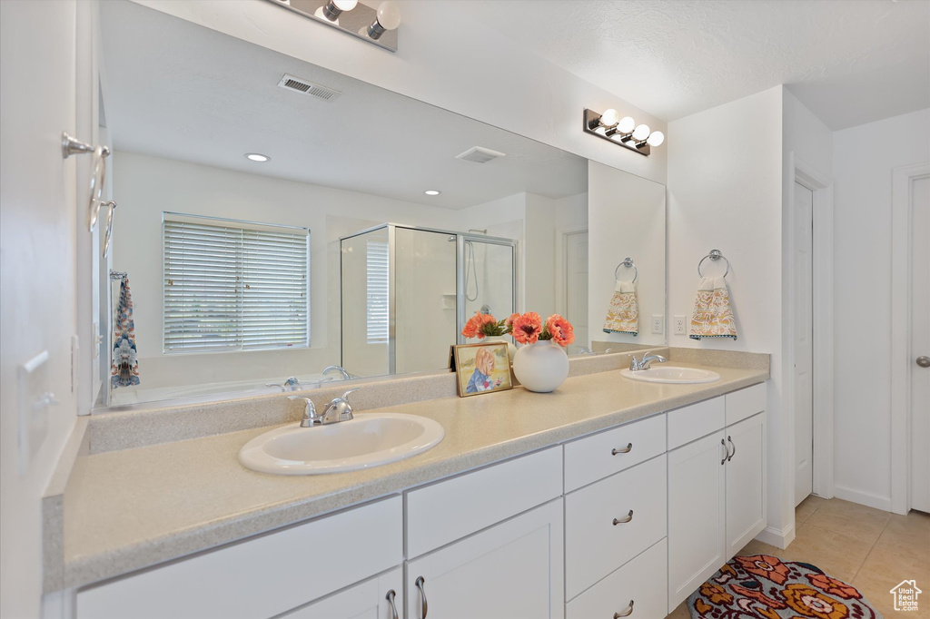 Full bath featuring a stall shower, tile patterned flooring, double vanity, and recessed lighting