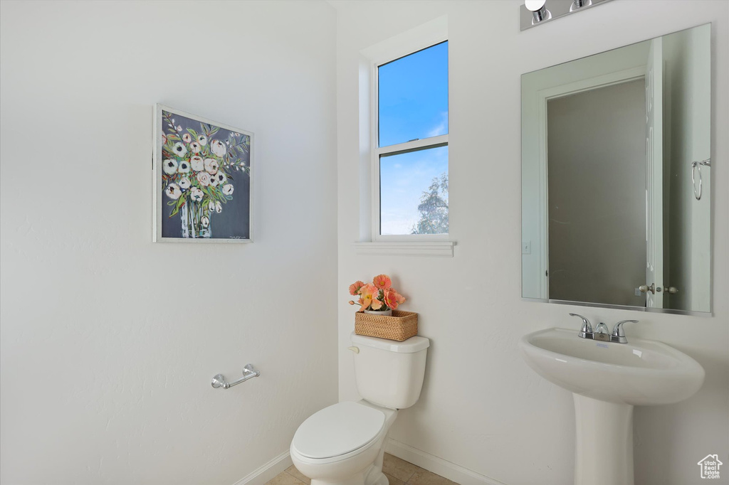 Bathroom with baseboards, toilet, and a sink