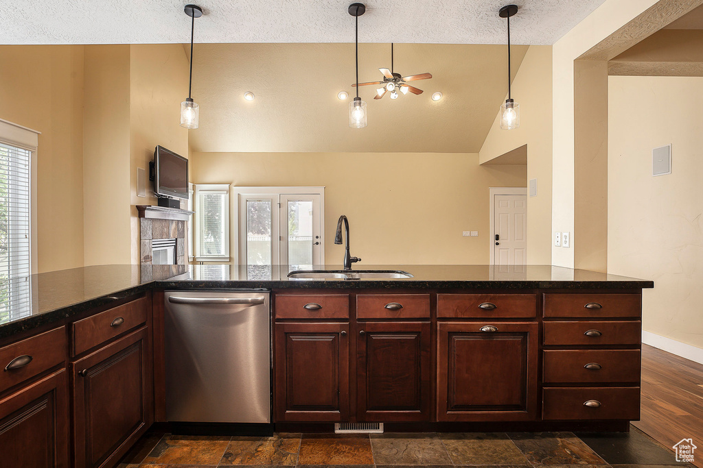 Kitchen featuring stainless steel dishwasher, a sink, ceiling fan, a textured ceiling, and high vaulted ceiling