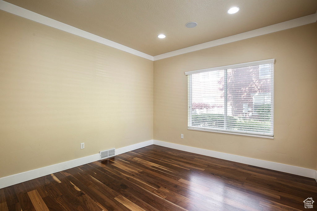 Spare room featuring baseboards, dark wood-style floors, recessed lighting, and ornamental molding