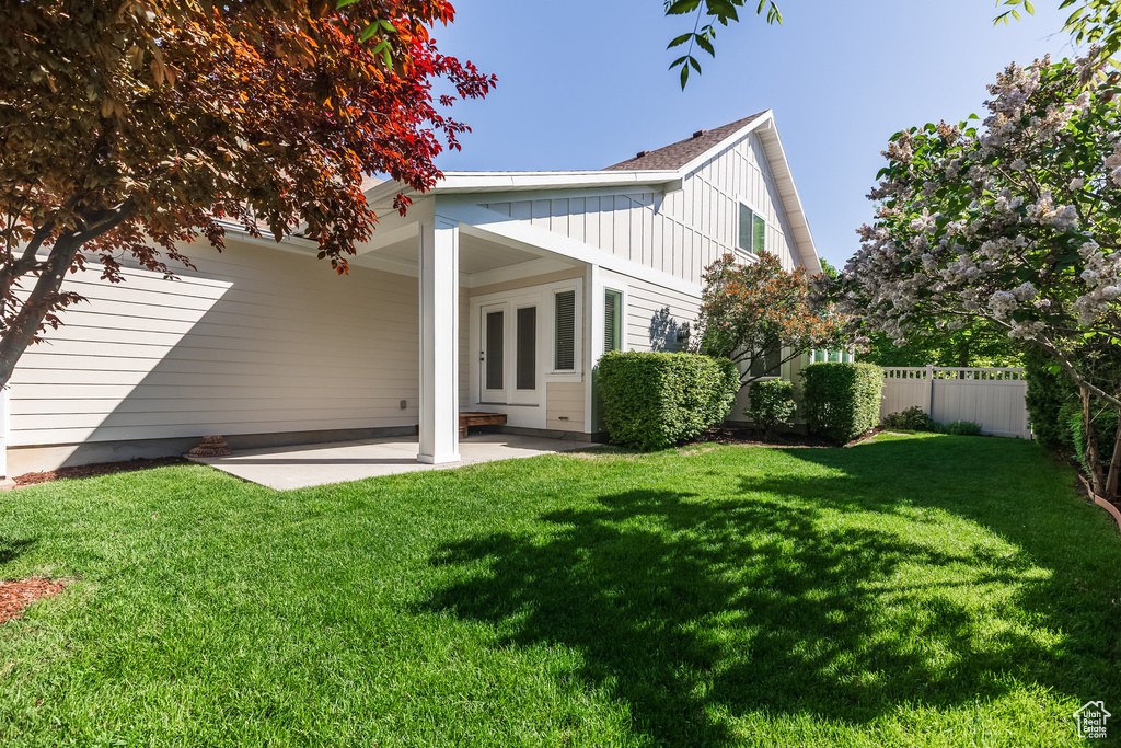 Back of house featuring board and batten siding and a patio area