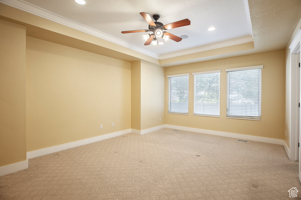 Spare room with crown molding, a ceiling fan, light colored carpet, recessed lighting, and baseboards