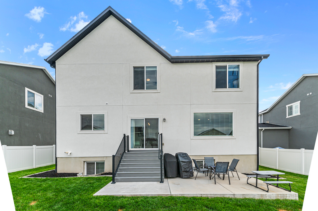 Back of property with stucco siding and a patio area