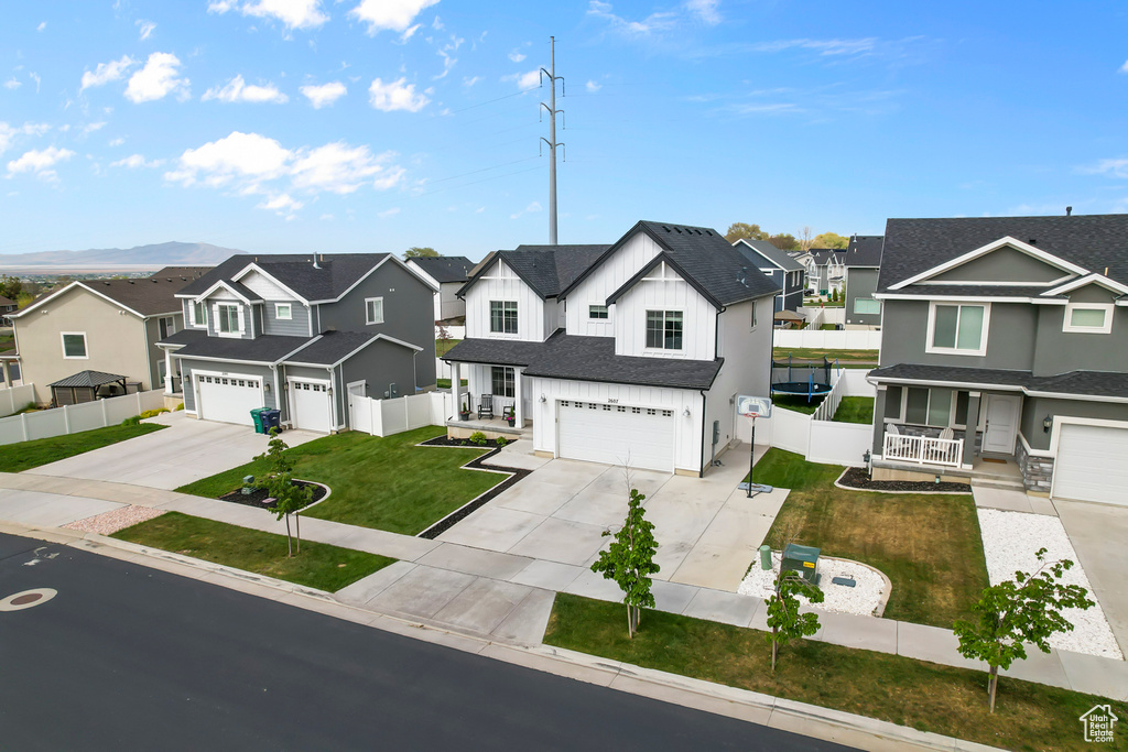 View of front facade featuring a residential view, a garage, driveway, and a porch