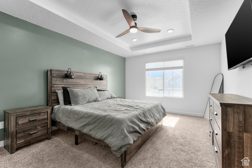 Bedroom featuring light carpet, a raised ceiling, a ceiling fan, baseboards, and recessed lighting