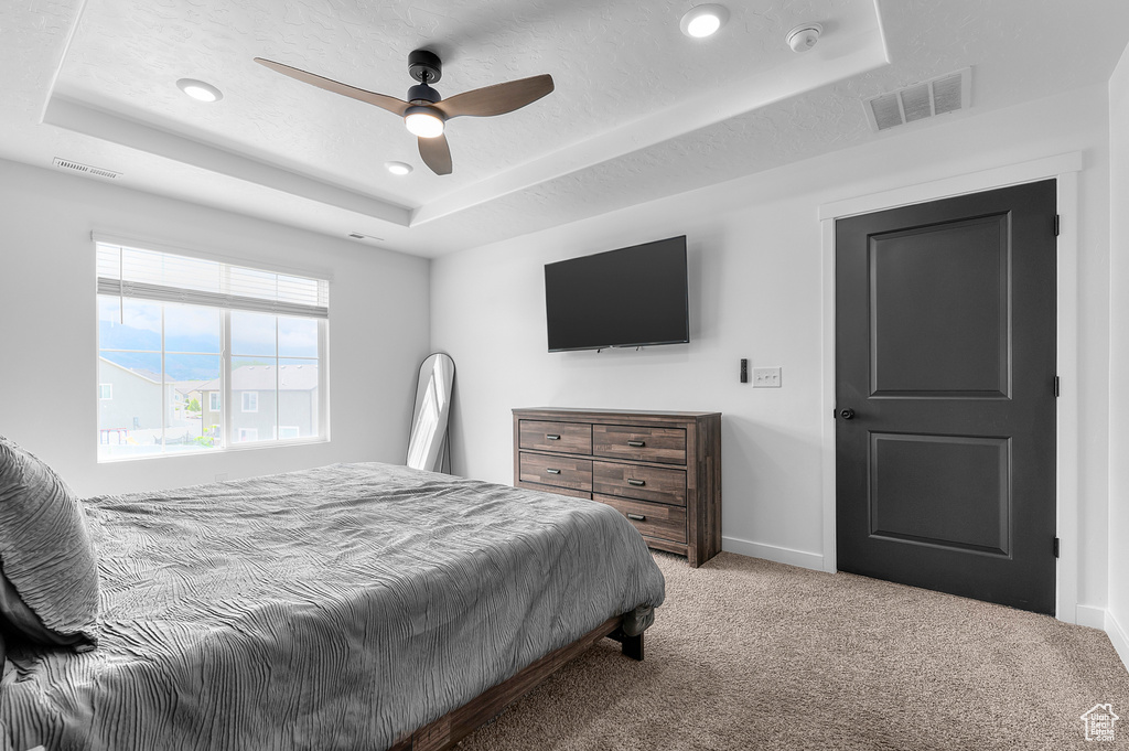 Bedroom with a tray ceiling, carpet floors, recessed lighting, baseboards, and ceiling fan