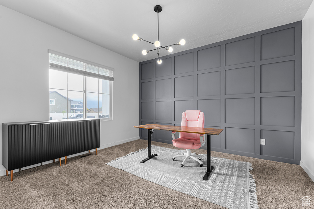 Office featuring a decorative wall, carpet, baseboards, and a chandelier