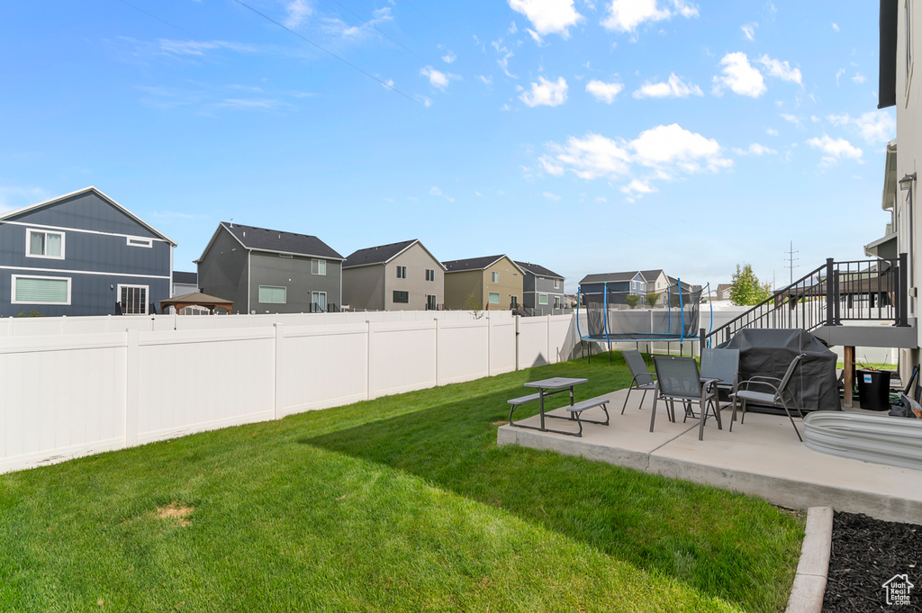 View of yard with a trampoline, a patio, a residential view, and stairway