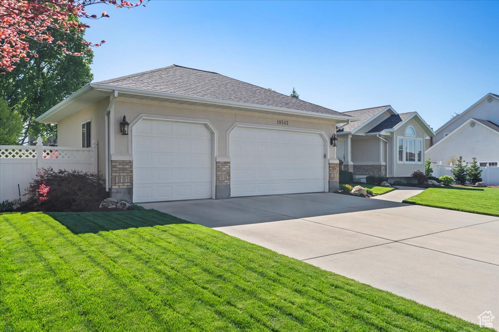 Ranch-style home with an attached garage, driveway, and stucco siding
