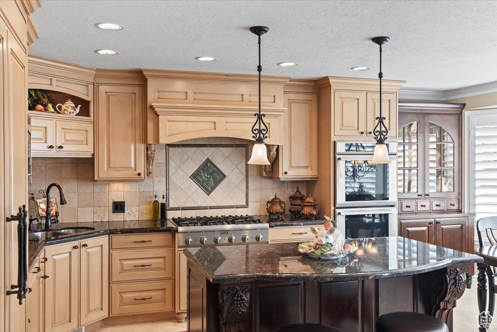 Kitchen featuring stainless steel double oven, a sink, open shelves, dark stone counters, and tasteful backsplash